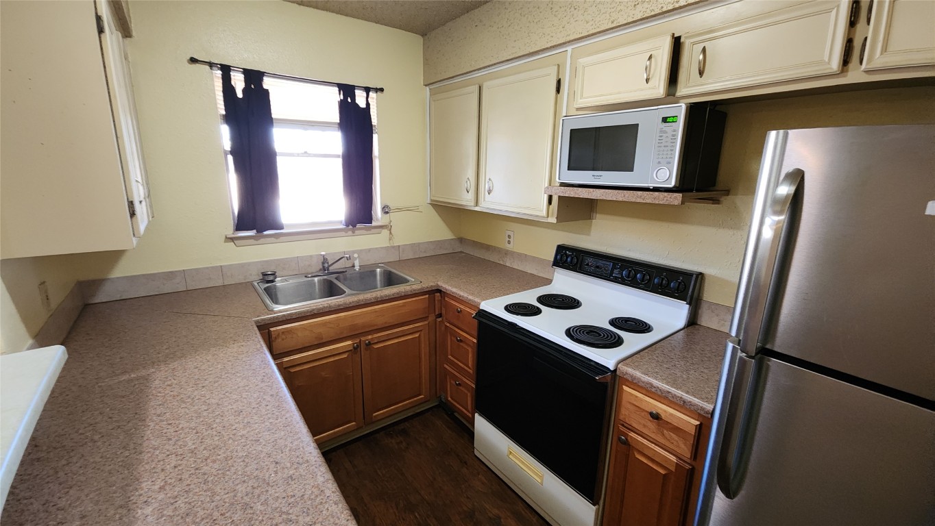 208 Vanderveer, Unit 4 Burnet, TX 78611 - Photo 6 of 13 a kitchen with stainless steel appliances granite countertop a stove a sink and a microwave