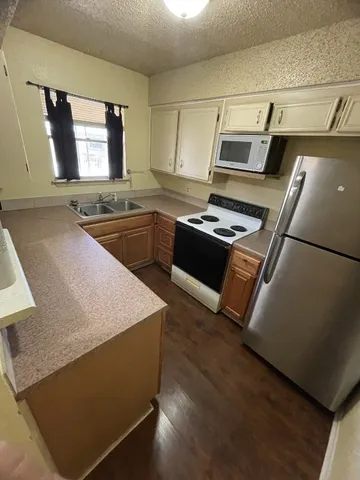a kitchen with kitchen island granite countertop a sink stove and refrigerator