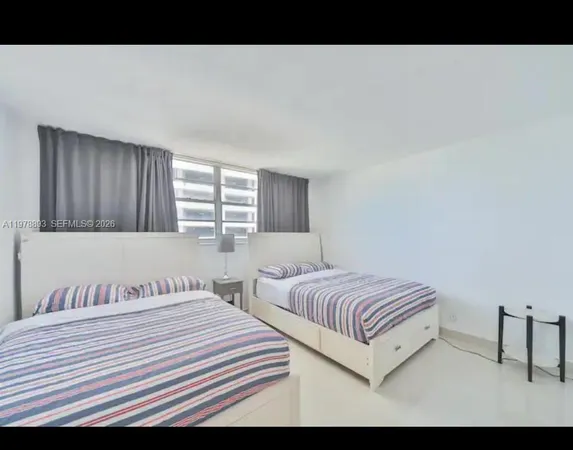 a bedroom with two bed and a window