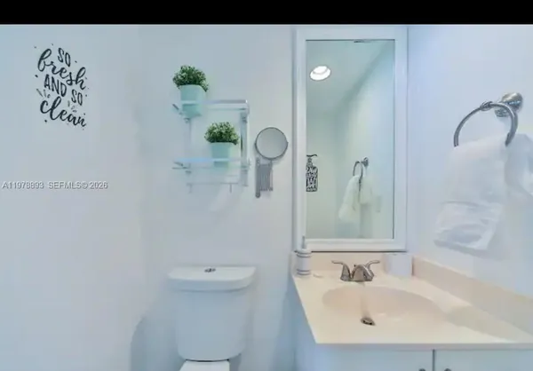 a bathroom with a sink and mirror with toilet