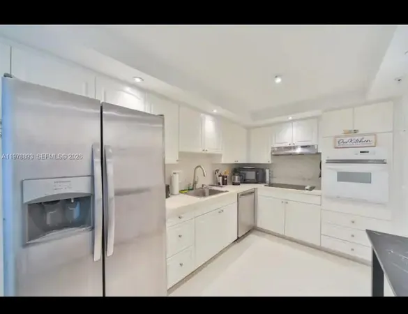 a kitchen with white cabinets and white appliances