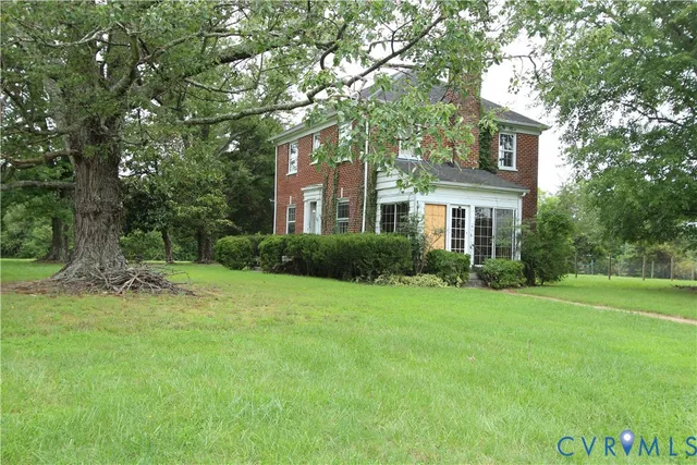 a front view of a house with a yard and trees