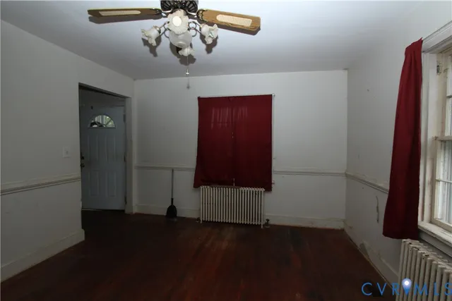 en empty room with wooden floor and windows