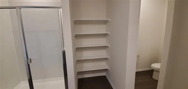 a view of walk in closet with empty racks
