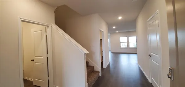a view of a hallway with wooden floor and staircase