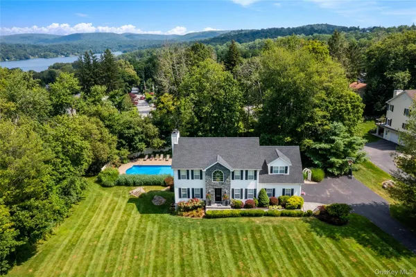 a view of a big house with a big yard and large trees
