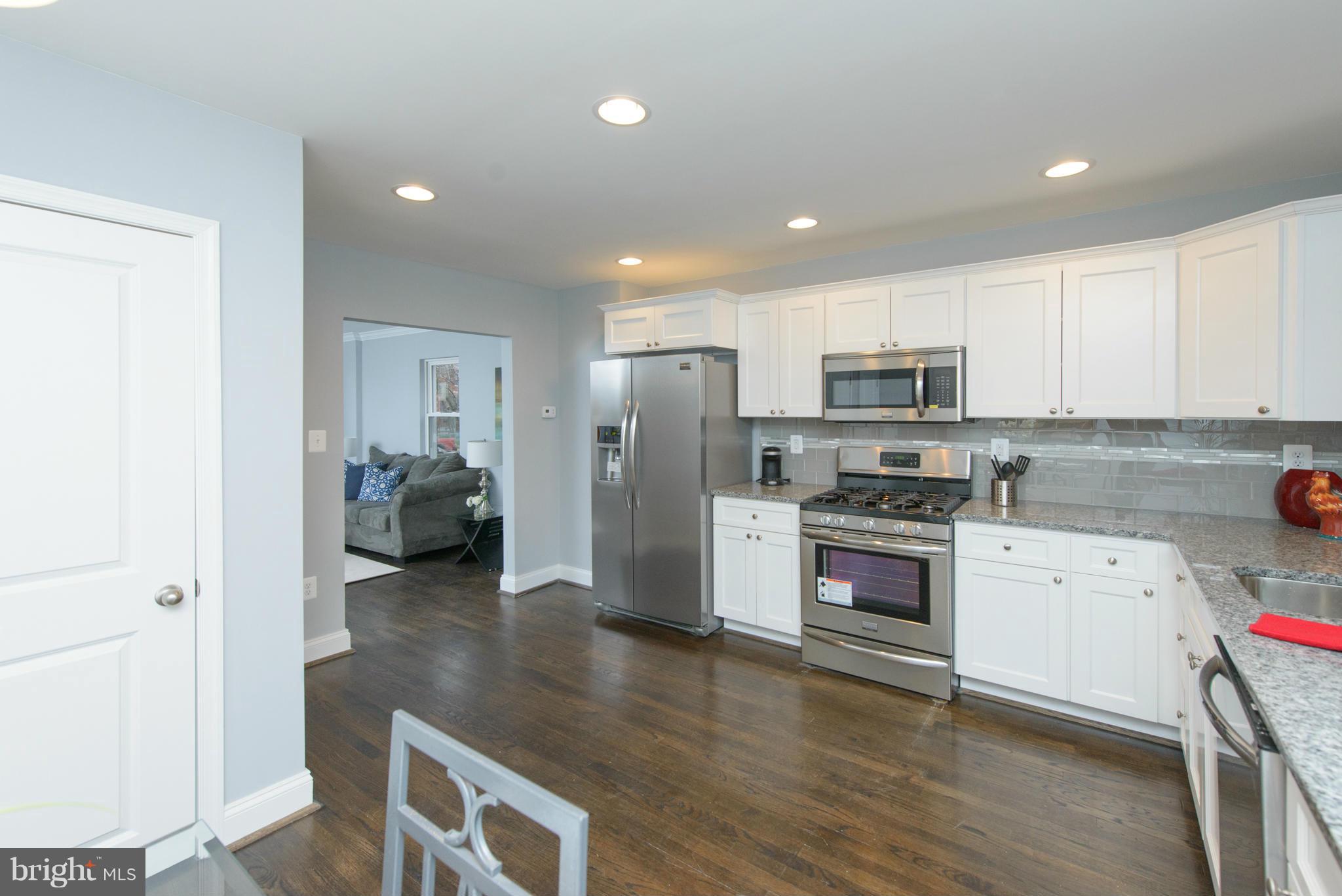 2127 Firethorn Road Baltimore, MD 21220 - Photo 6 of 30 a kitchen with a refrigerator a stove top oven a sink and cabinets