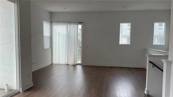 an empty room with wooden floor and a window