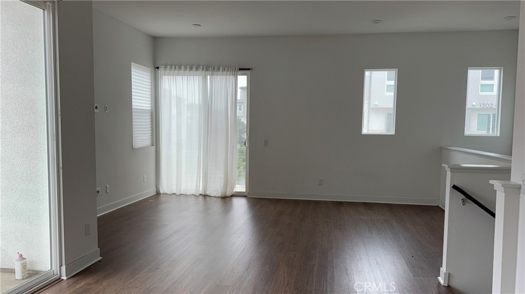 1402 West Bushell Street Anaheim, CA 92805 - Photo 3 of 10 an empty room with wooden floor and a window