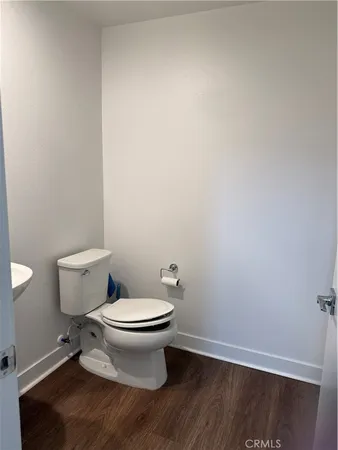 a white toilet sitting next to a white wall
