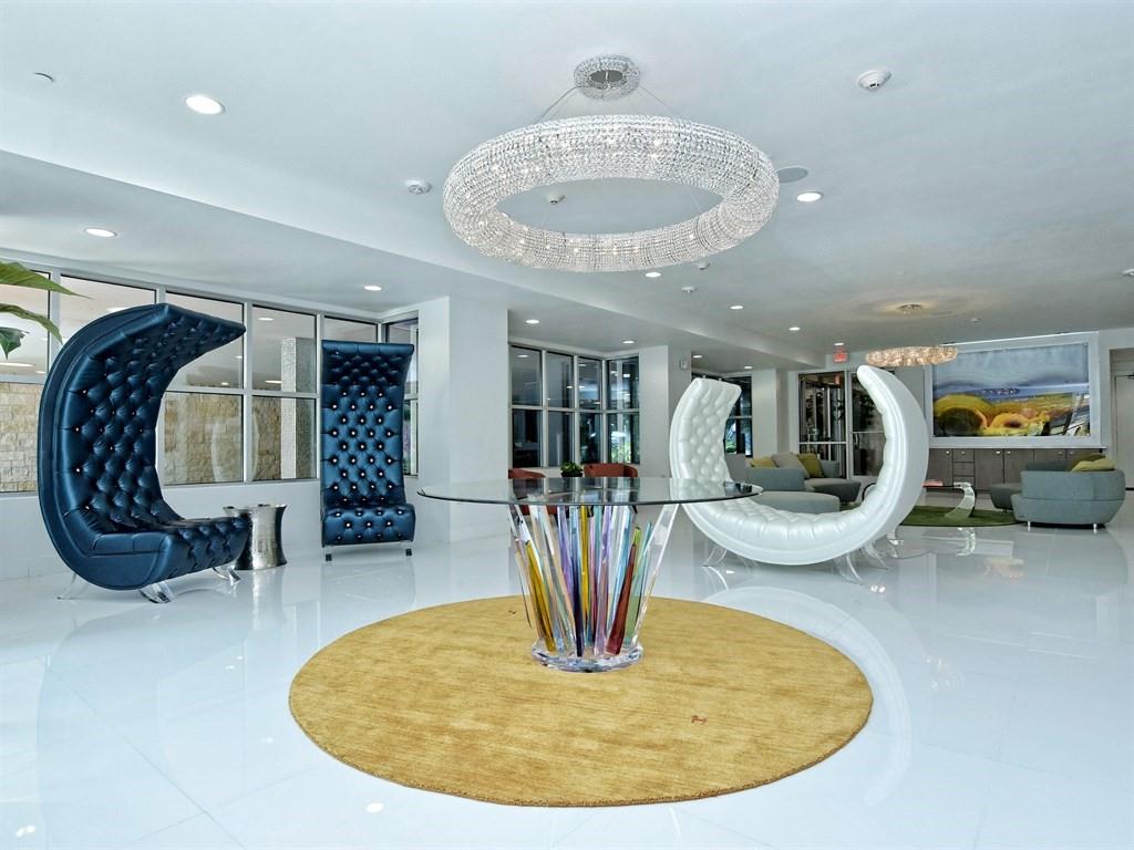 1900 Barton Springs Road, Unit 3040 Austin, TX 78704 - Photo 24 of 38 Spacious lobby featuring a large circular crystal chandelier, white polished flooring, and a round area rug