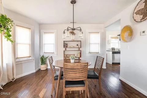 a dining room with furniture a chandelier and wooden floor