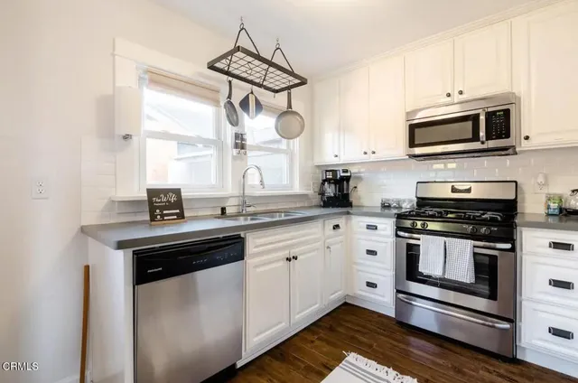 a kitchen with stainless steel appliances granite countertop a sink a stove and microwave