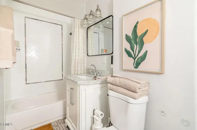 a bathroom with a granite countertop sink a toilet and shower