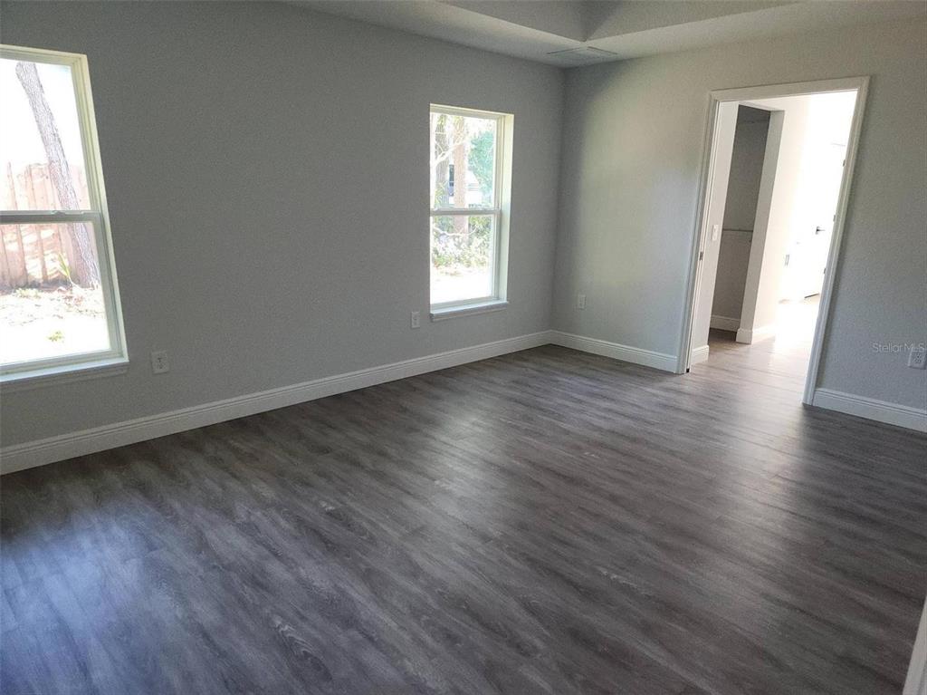 1111 Dagmar Avenue Spring Hill, FL 34606 - Photo 3 of 27 an empty room with wooden floor and windows
