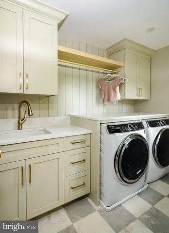 a utility room with sink dryer and washer