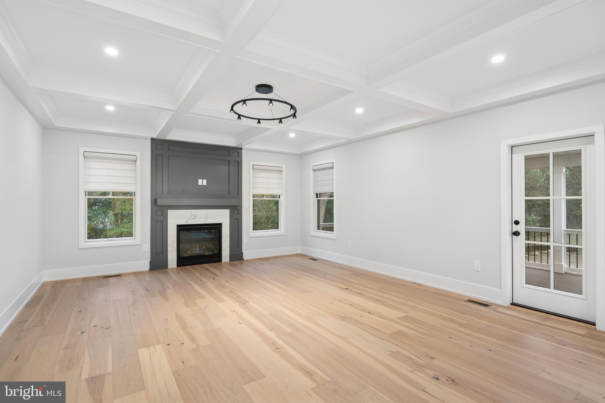 211 Bella Vista Road Devon, PA 19333 - Photo 12 of 16 an empty room with windows fireplace and wooden floor