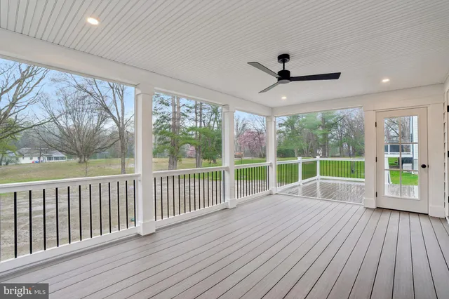 a view of an empty room with wooden floor and balcony