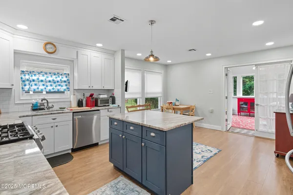 a kitchen with granite countertop a sink window and cabinets