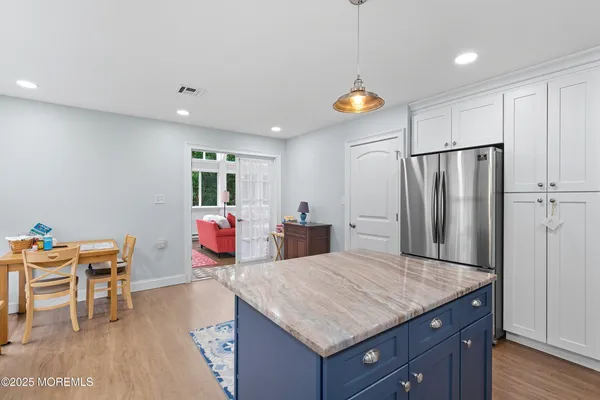 a kitchen with stainless steel appliances granite countertop a table chairs and a refrigerator