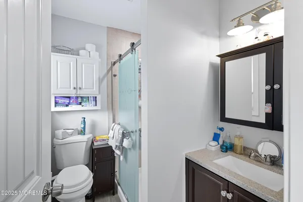 a bathroom with a toilet sink vanity and mirror
