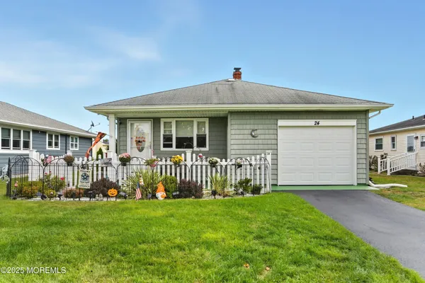 a front view of a house with a garden and yard