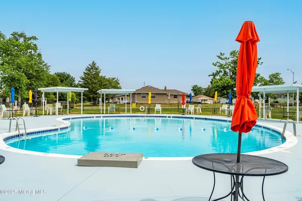 a front view of a house with swimming pool garden and outdoor seating
