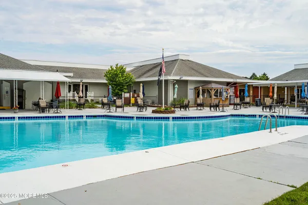 a swimming pool view with a seating space and a garden view