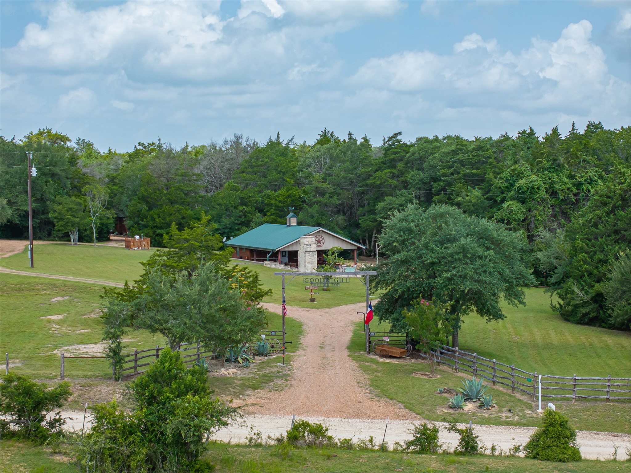 10900 Mayer Cemetery Road Burton, TX 77835 - Photo 1 of 24 a view of a garden with lawn chairs under an umbrella