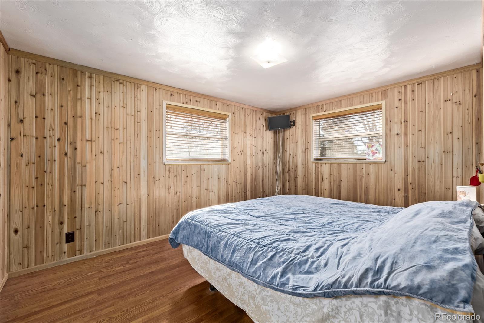 8227 Depew Way Arvada, CO 80003 - Photo 21 of 31 a bedroom with a bed and wooden floor