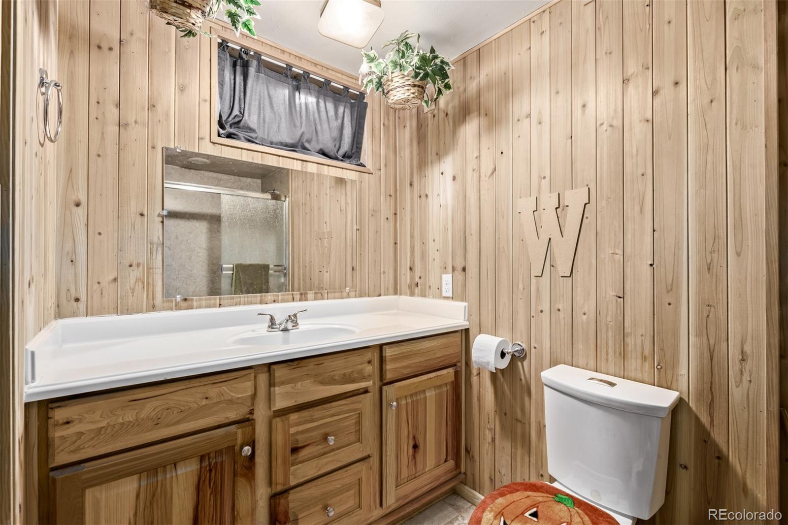 8227 Depew Way Arvada, CO 80003 - Photo 24 of 31 a bathroom with a sink a toilet a mirror and shower curtain