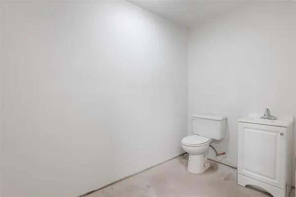 a white toilet sitting next to a white cabinet