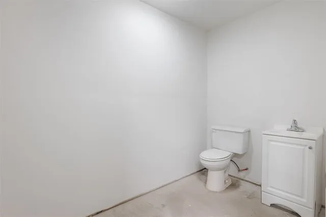 a white toilet sitting next to a white cabinet