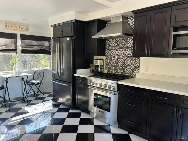 a kitchen with a stove a refrigerator and cabinets
