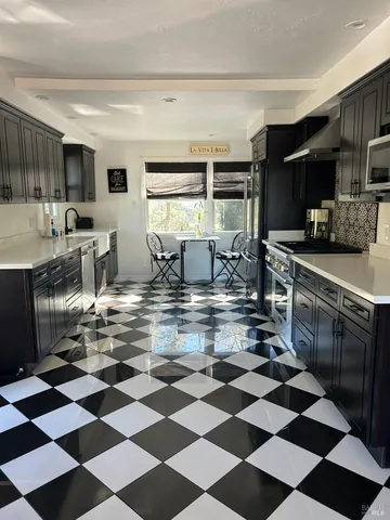 a kitchen with a checkered floor and white cabinets