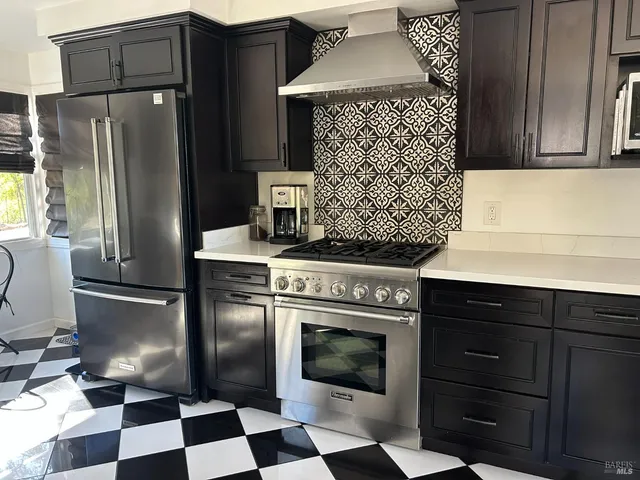a kitchen with a stove a refrigerator and cabinets