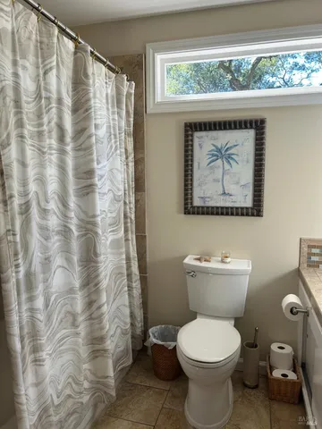 a bathroom with a toilet and a shower curtain