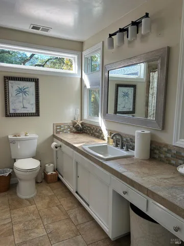 a bathroom with a toilet sink and mirror