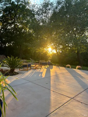 a backyard of a house with table and chairs and potted plants