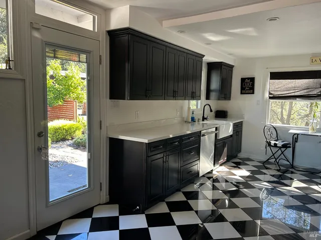 a kitchen with granite countertop stainless steel appliances a stove a sink and a window