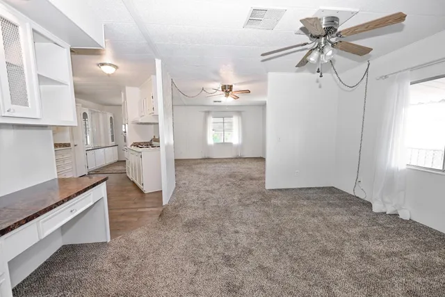 an empty room with windows and chandelier