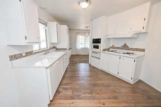 a kitchen with granite countertop white cabinets and white appliances