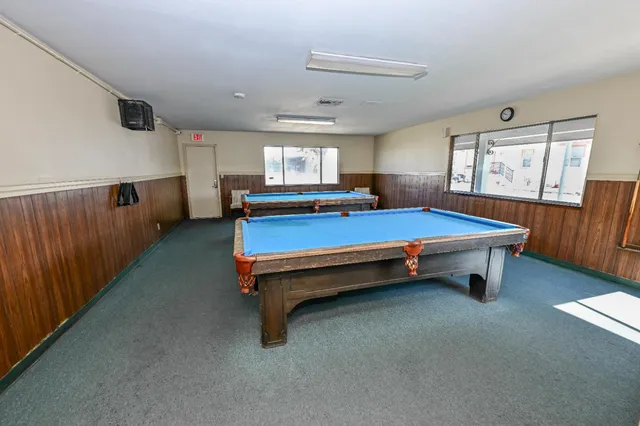 a living room with furniture and a dining table with wooden floor
