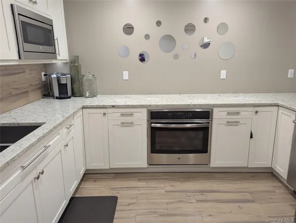a view of a kitchen with cabinets and stainless steel appliances