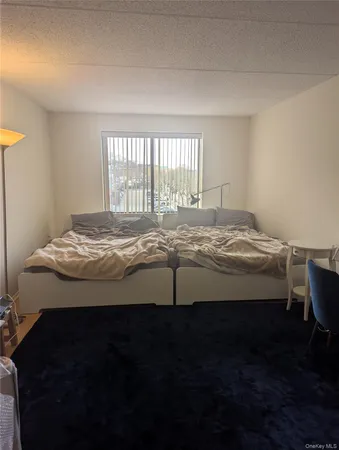 a bedroom with a bed dresser and a window