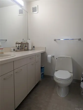 a bathroom with a toilet sink and mirror