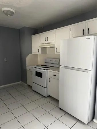 a white refrigerator freezer and a stove sitting inside of a kitchen