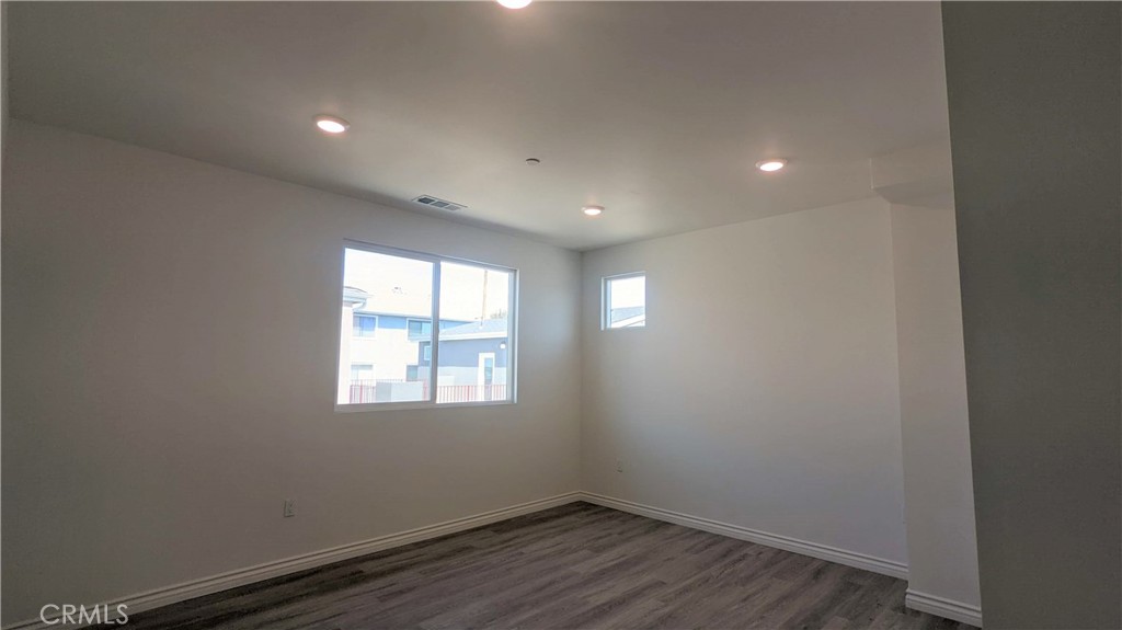 15115 Logos Court North Hills, CA 91343 - Photo 15 of 21 an empty room with wooden floor and windows