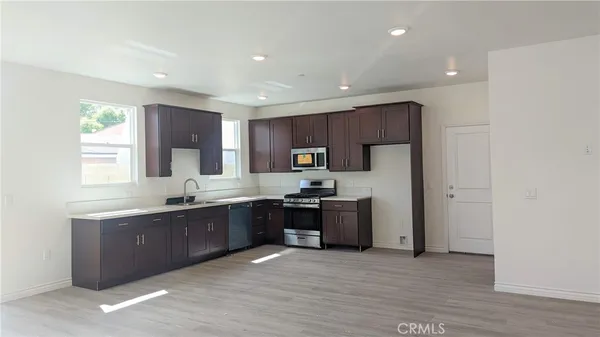 a large kitchen with stainless steel appliances granite countertop a stove a sink and a refrigerator