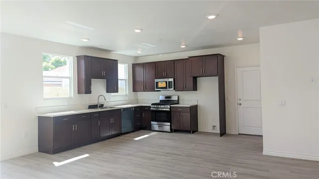 a large kitchen with stainless steel appliances granite countertop a stove a sink and a refrigerator